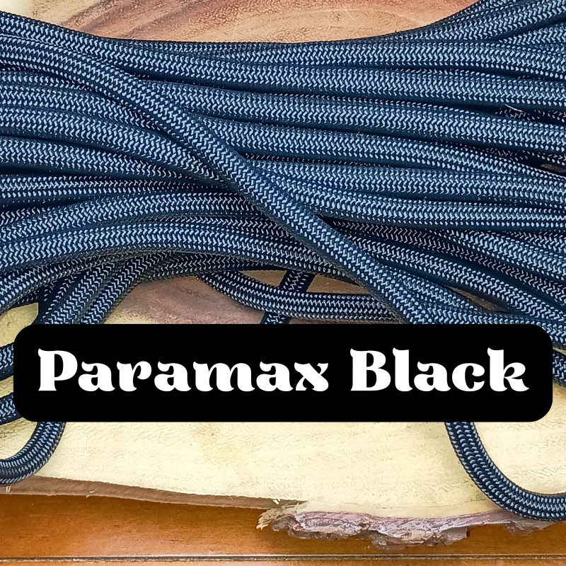 Close-up of a pile of black and white patterned paracord laces on a wooden surface with a label that reads "Paramax Black."
