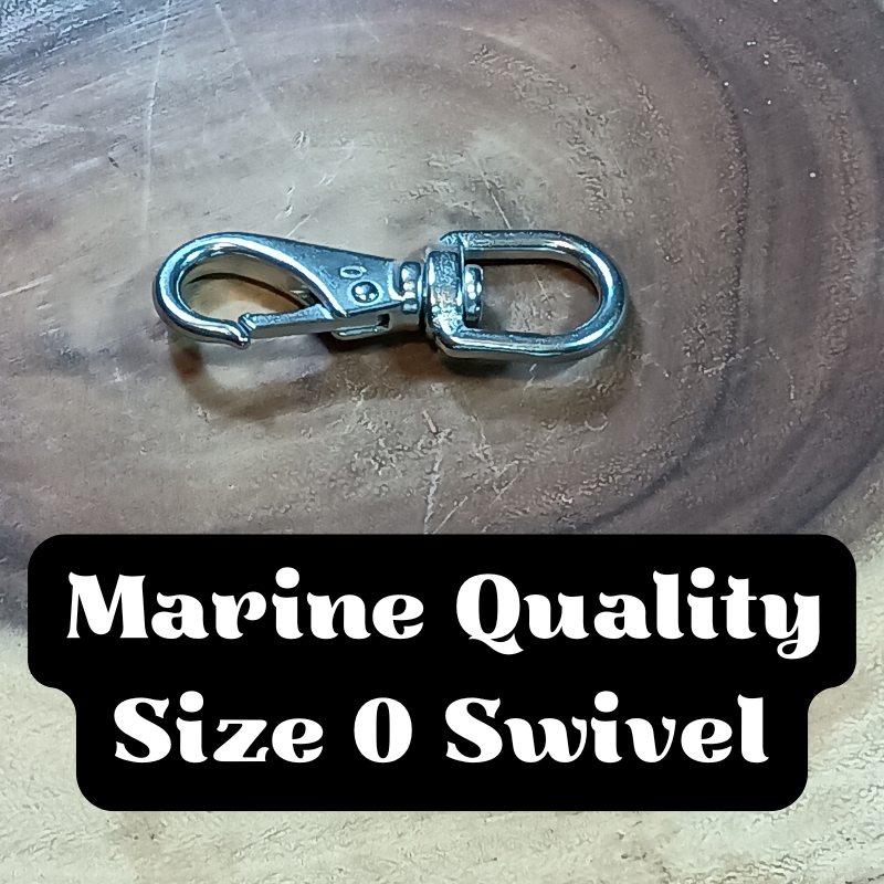 A marine quality size 0 swivel with a metal clasp attached, placed on a wooden surface.