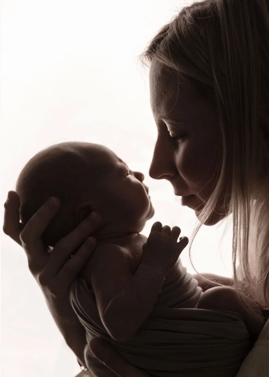 Mother gazing at her newborn baby during an at-home photography session in London