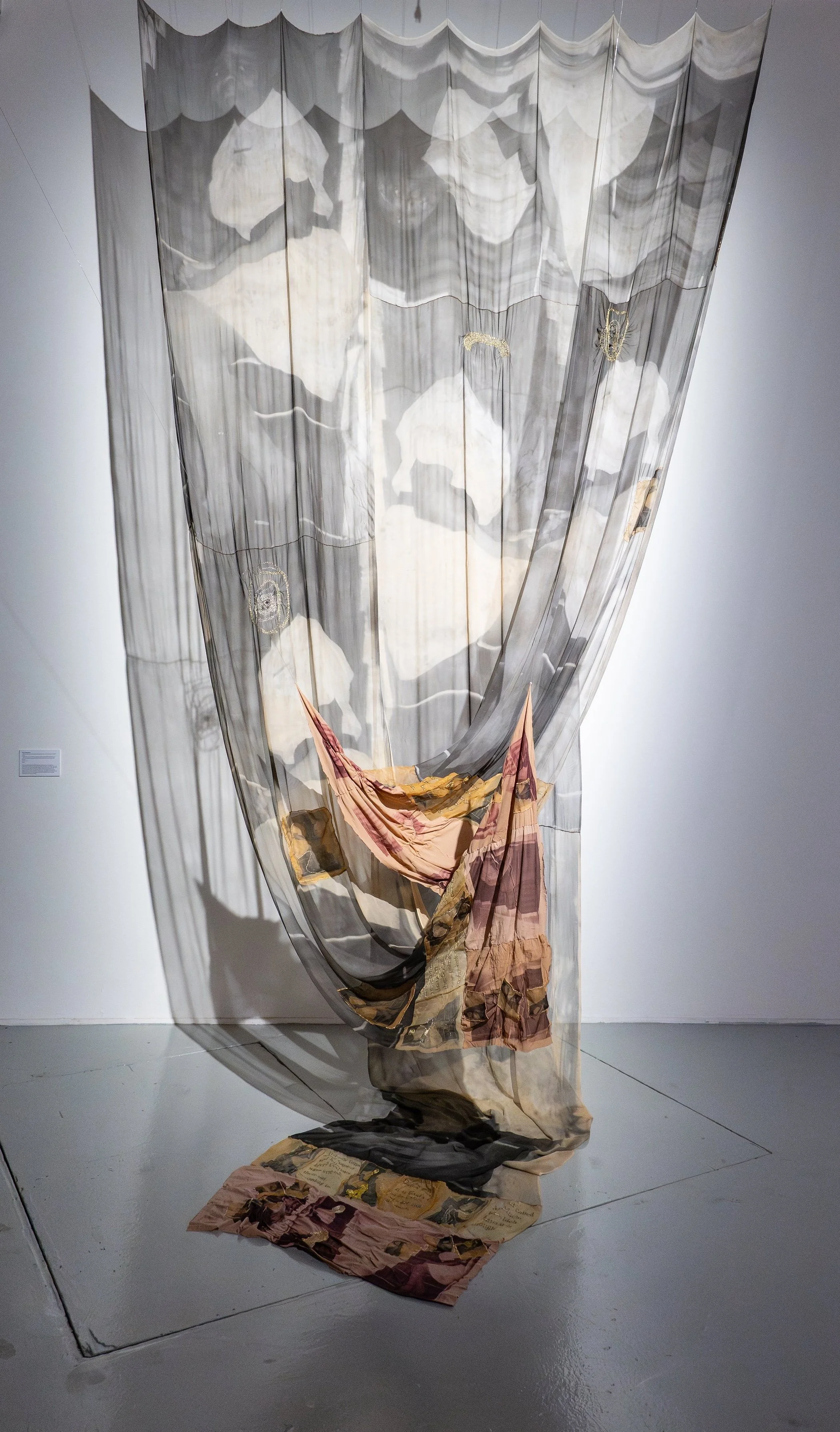 Lɔ̃lɔ̃ kple ŋku ɖoɖo, amedada ƒe nutinya dzi (Love and memory a mother’s story), 2025, 10.75 x 19ft / 3.3 x 5.8m, digital print on silk chiffon and silk organza, dye sublimation print on used nylon tights, cotton thread, metallic acrylic thread and r