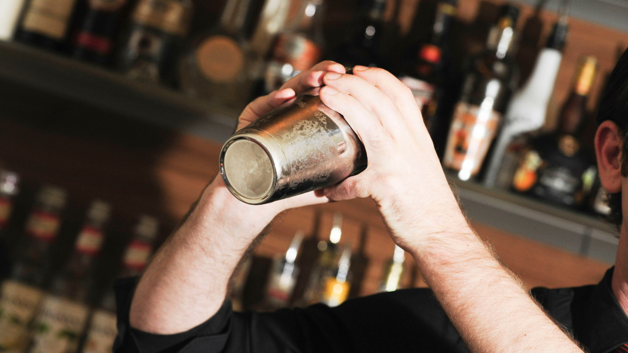 Pessoa segurando uma lata de alumínio em uma loja de bebidas.