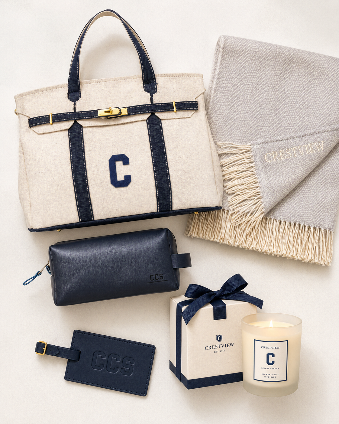 Collection of navy and beige accessories, including a tote bag, scarf, wallet, keychain, custom box, and candle.
