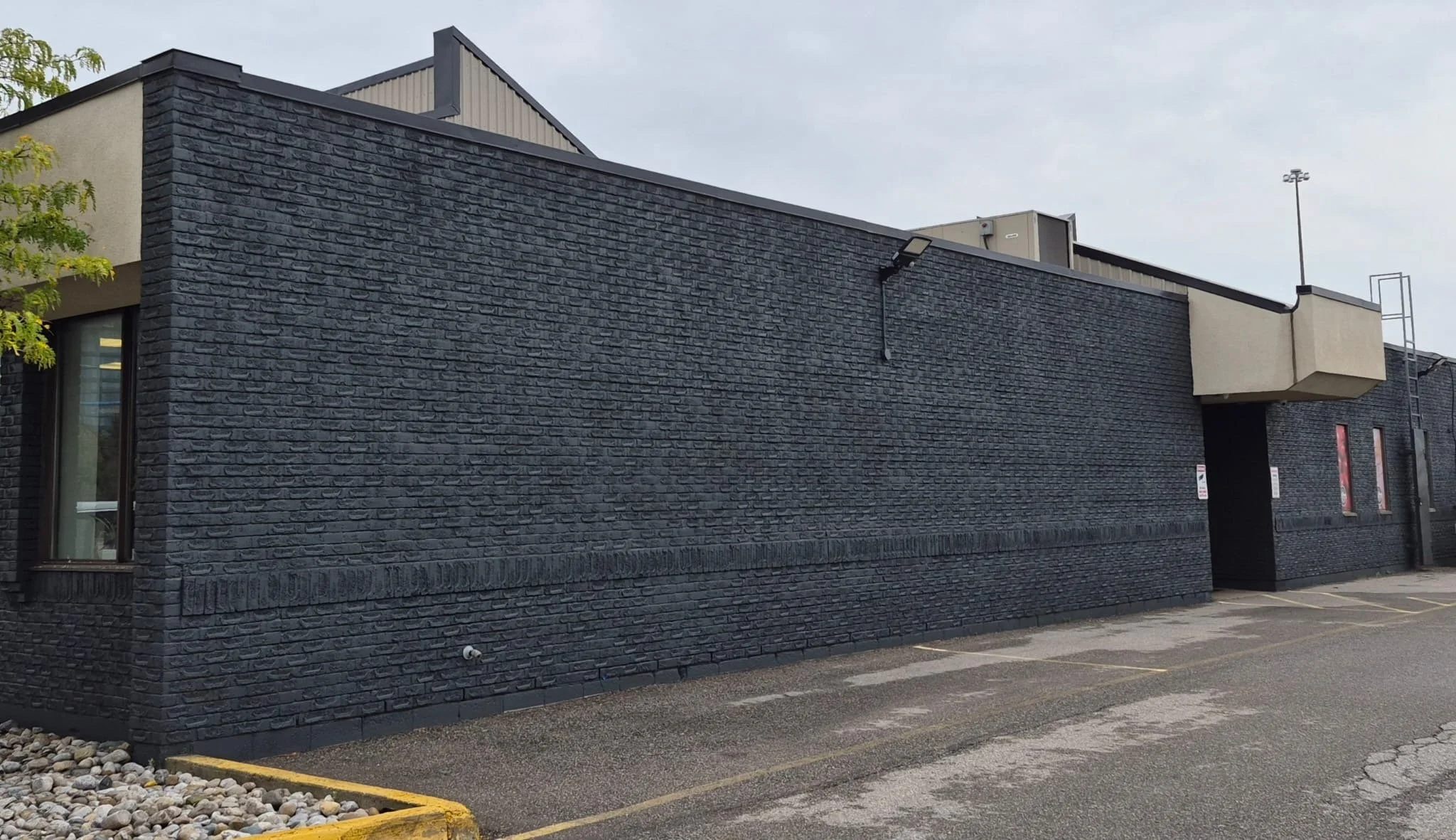 Dark masonry wall with previous repairs colour matched
