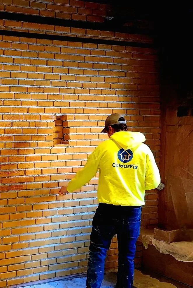 ColourFix worker applying a colour sample to a brick wall