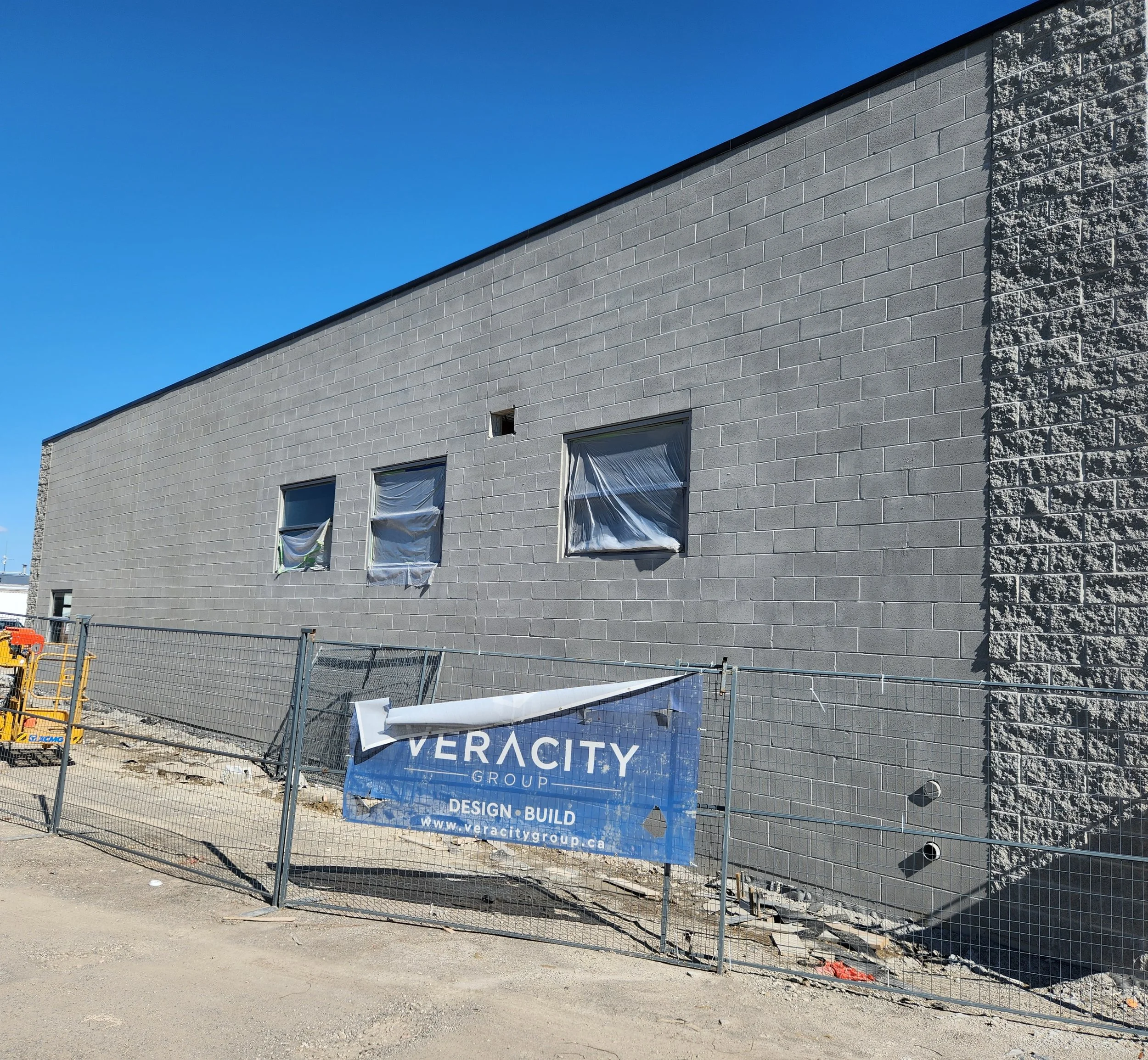 Construction site with a partially built gray brick building.
