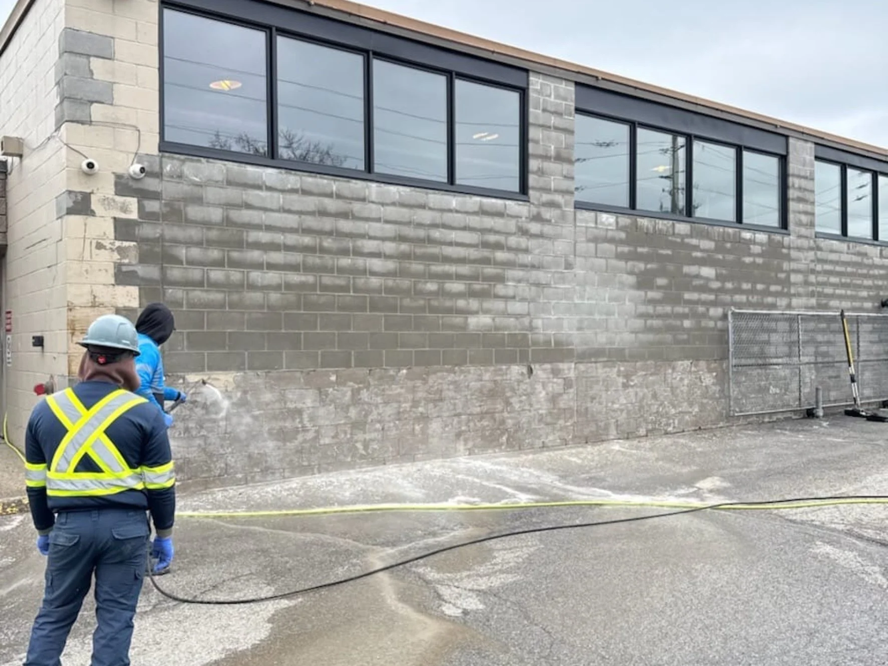 Worker removing paint from a masonry wall
