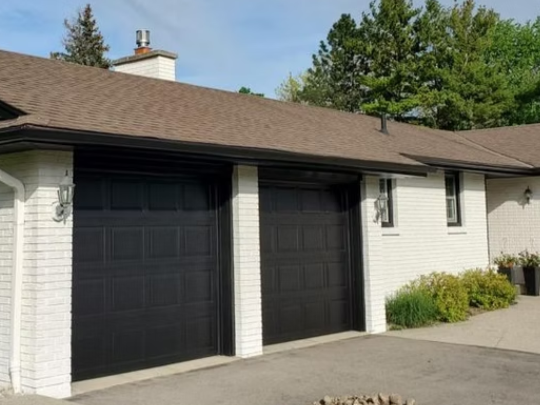 Residential brick home with black garage doors after colour change