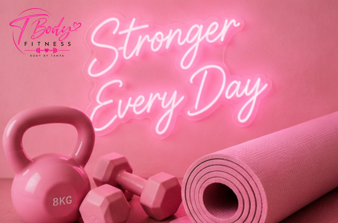 Pink rolled yoga mat, pink kettlebell labeled 8KG, two pink dumbbells, and a pink neon sign that says 'Stronger Every Day' with a pink background.