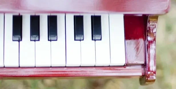 Close-up of a red vintage piano keyboard showing white and black keys.