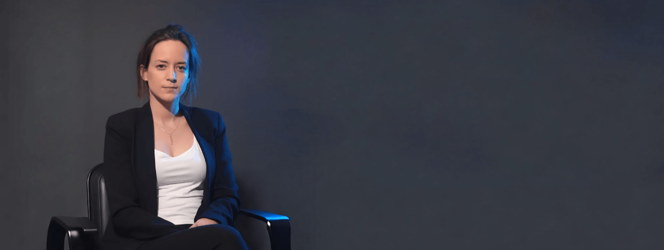 Adriana Ortiz, fundadora de Salud Nuclear, sentada en un sillón sobre un fondo oscuro.