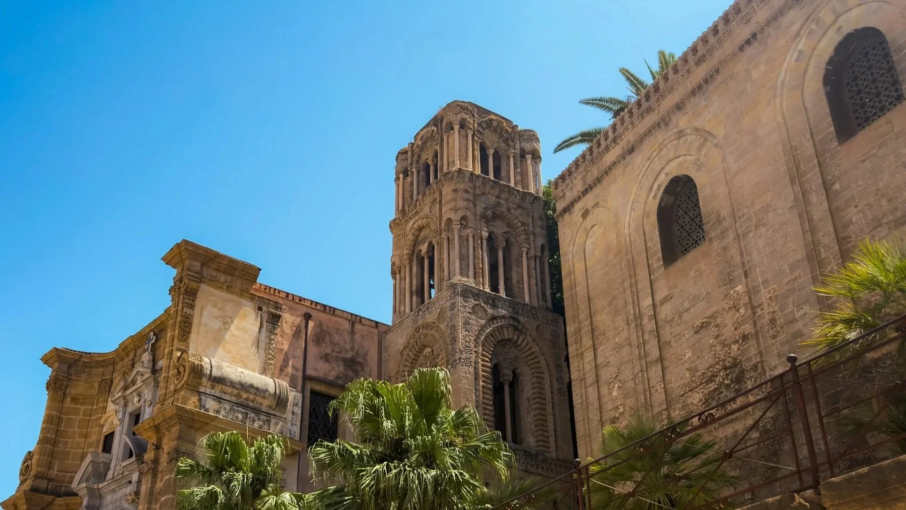 Historic stone churches of La Martorana and San Cataldo in Piazza Bellini, Palermo, beneath a clear blue sky.