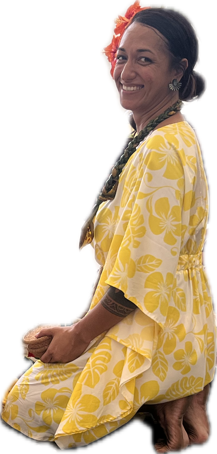 Femme souriante en tenue hawaïenne jaune avec fleurs, portant un collier tressé, un tatouage sur le bras, une grande fleur dans les cheveux, tenant un coquillage