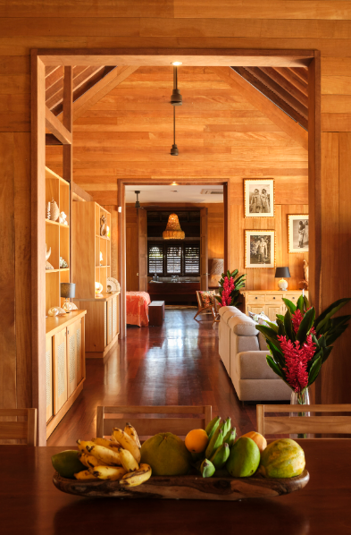 Intérieur d'une maison en bois avec salon, fenêtres, et décoration.