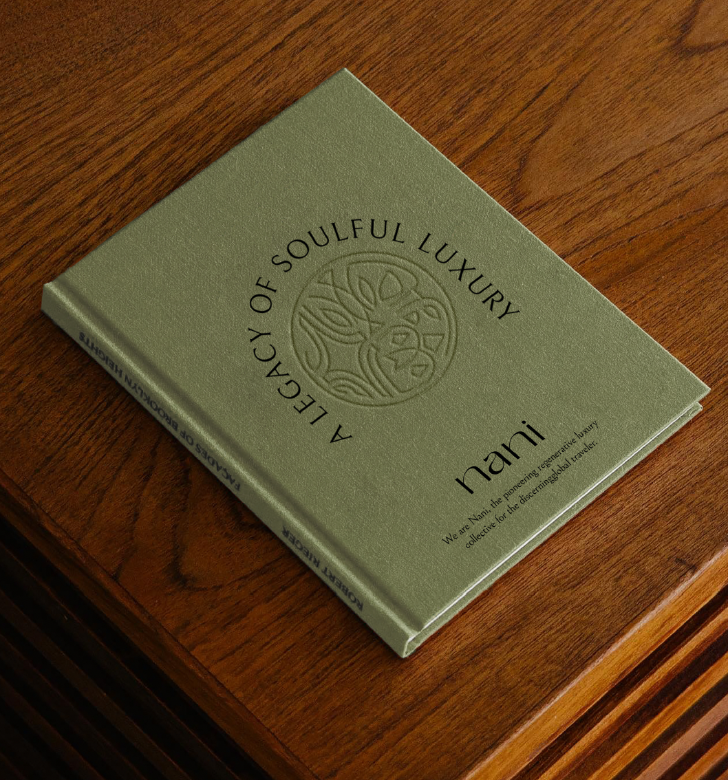Livre vert intitulé « A Legacy of Soulful Luxury » posé sur une table en bois.