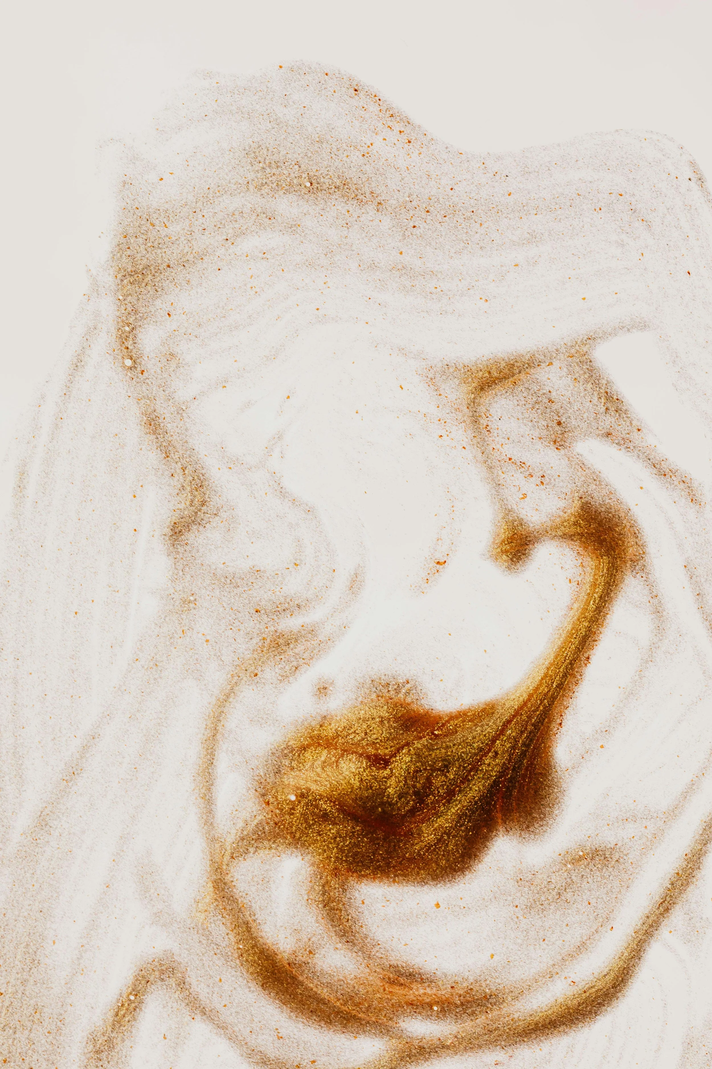 Close-up of a woman's face with a sand or spice pattern overlay, creating an artistic effect.