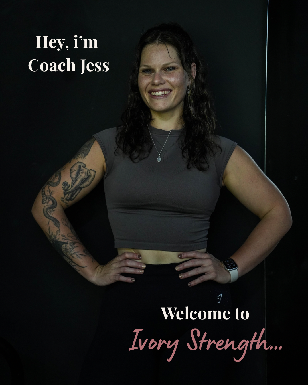 A smiling woman with tattoos on her arms, wearing a gray sleeveless crop top and black leggings, standing with hands on her hips against a dark background. Text overlay says "Hey, I’m Coach Jess" and "Welcome to Ivory Strength..."