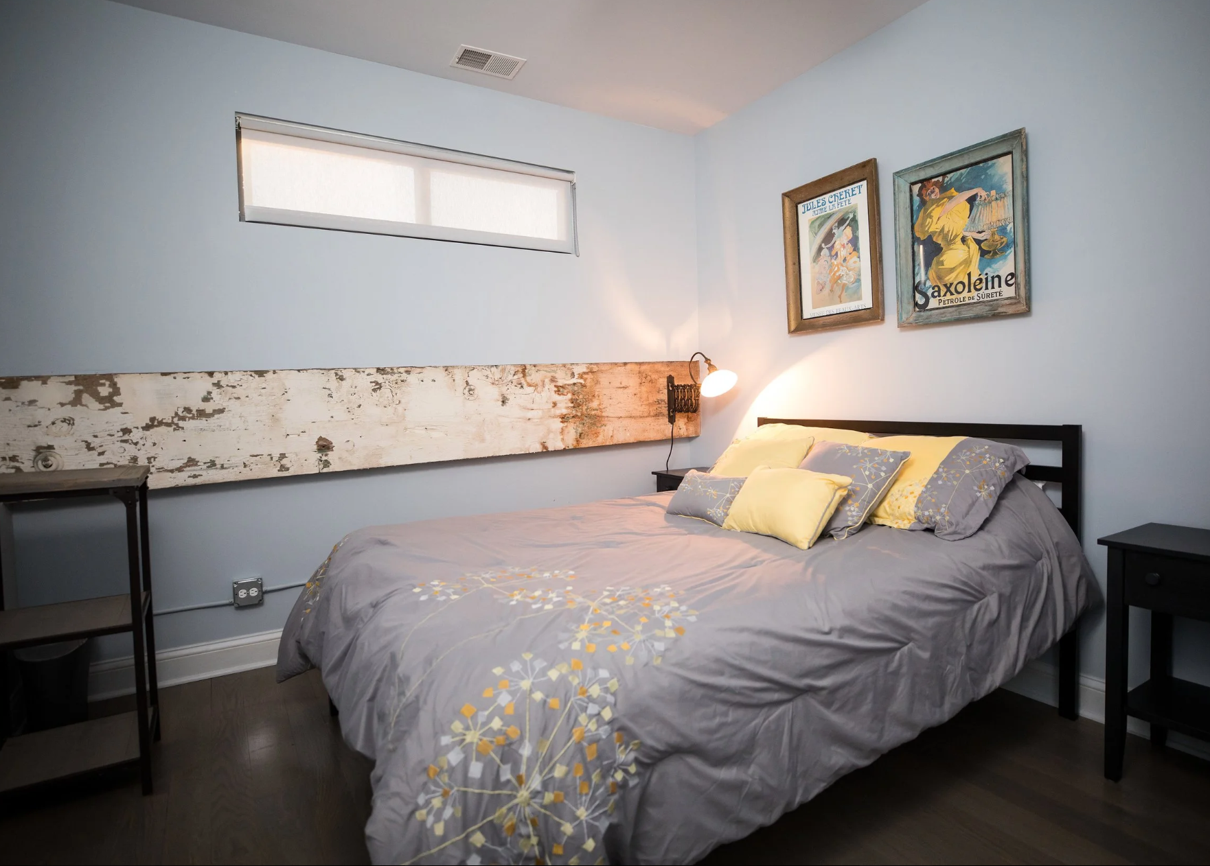 image of a bedroom at the hideout apartment inside the joinery wedding venue, with a queen bed and artwork on the wall