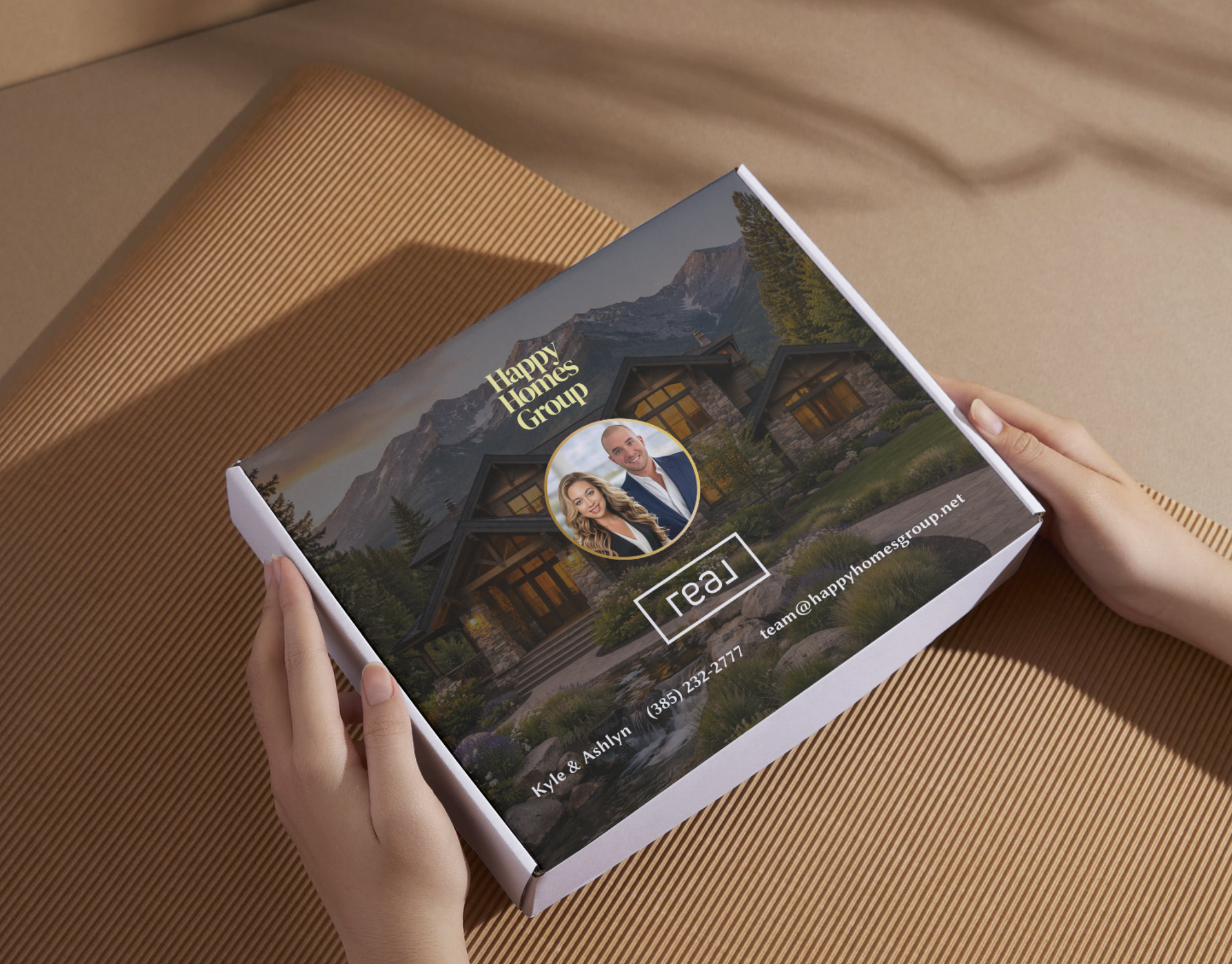 Close-up of a brochure titled 'Happy Homes Group' held by person with hands, featuring a house, mountains, trees, and photos of people on a tan background.