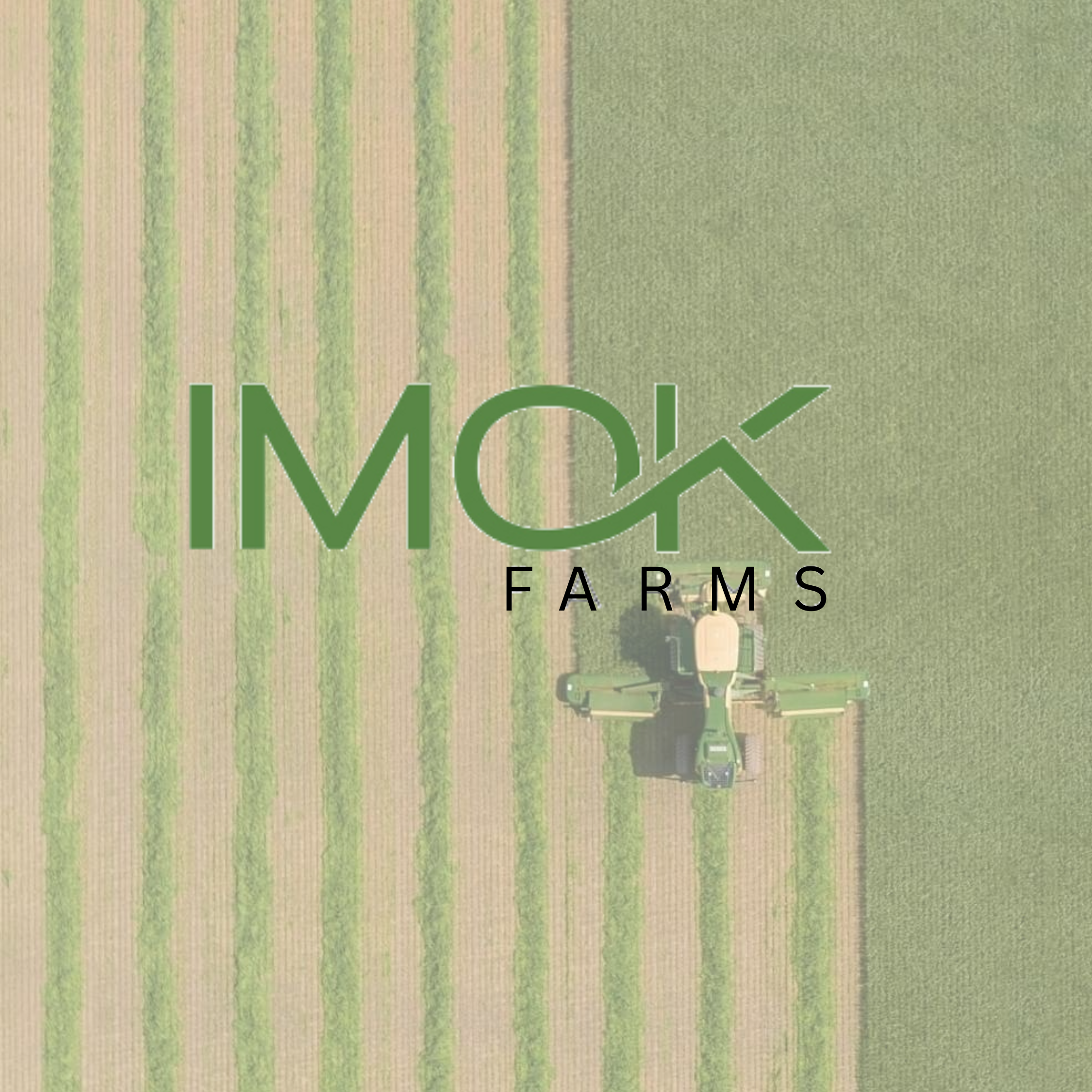 Aerial view of a farm with orchards, fields, and a paved driveway, with a small building and several vehicles parked nearby.