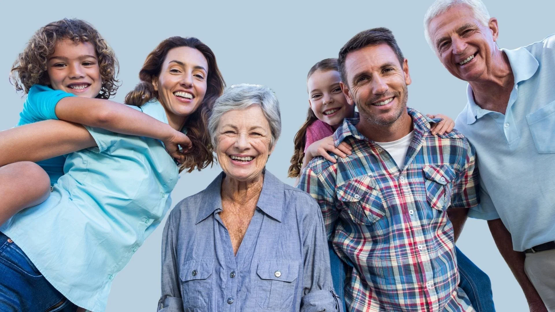Family of seven smiling and laughing together outdoors against a blue background.