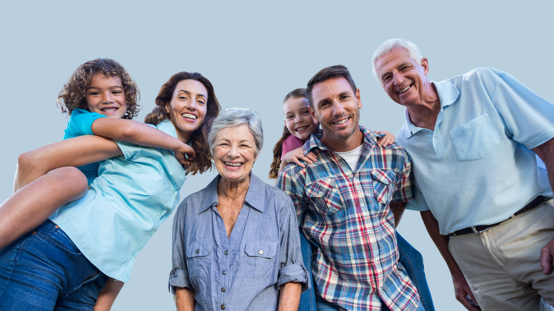 A diverse multigenerational family posing outdoors against a clear sky, smiling and enjoying each other's company.