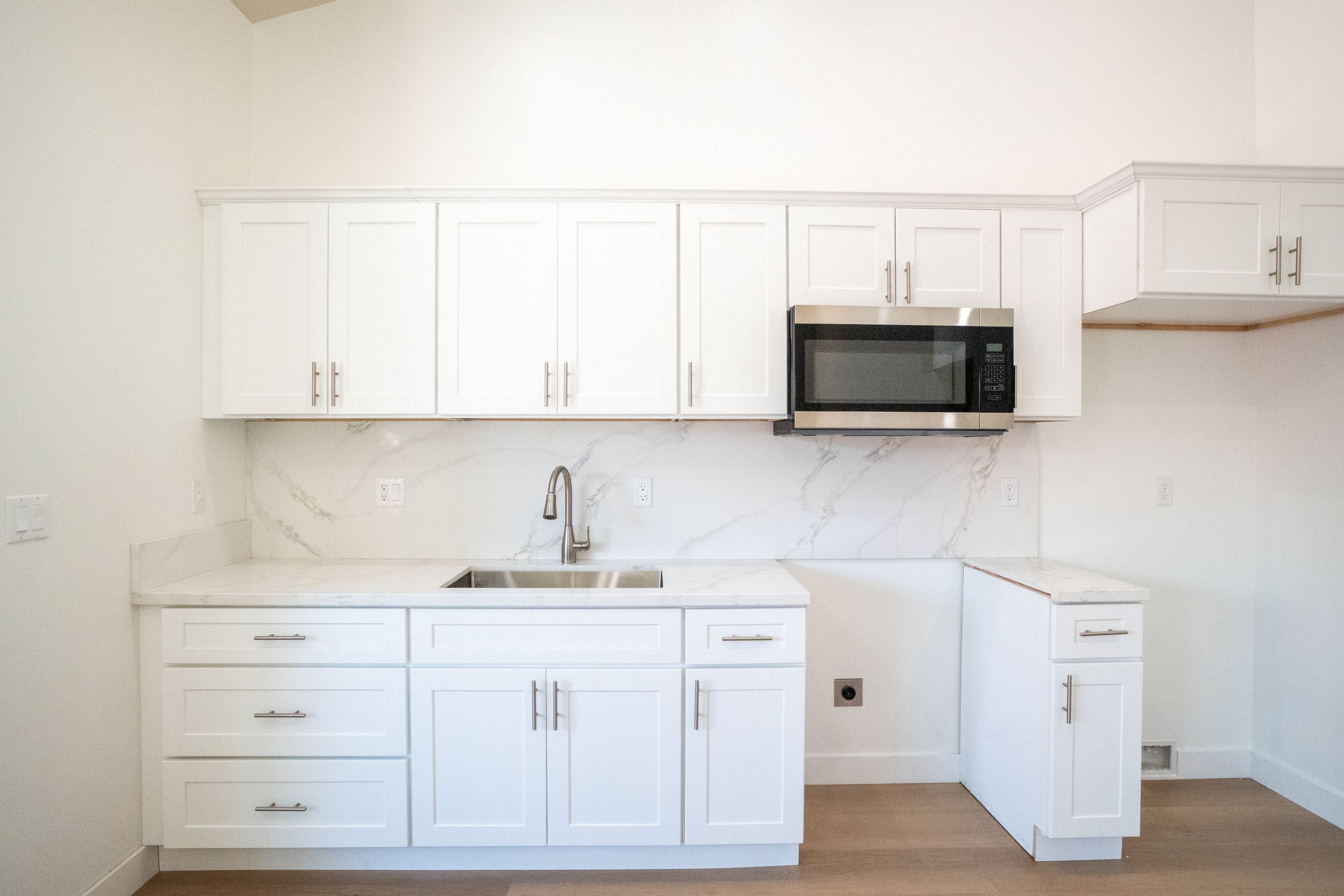 Close up of the kitchen area providing ample space and pending the installation of a dishwasher and an oven. 