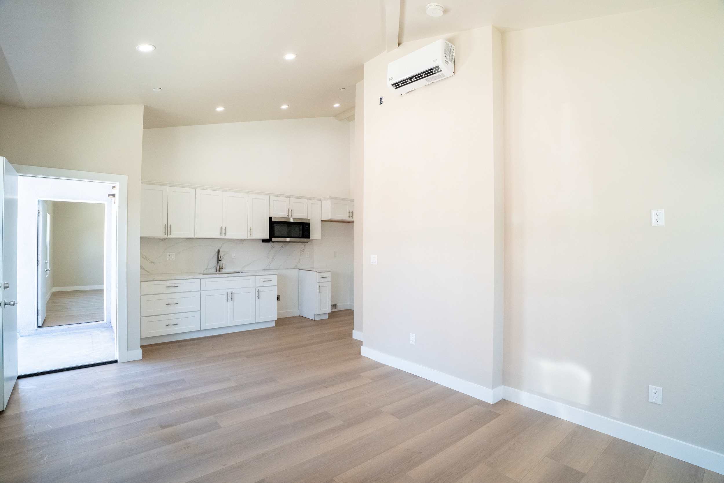 Jack and Jill units with a look at the kitchen and the high ceilings within the property.