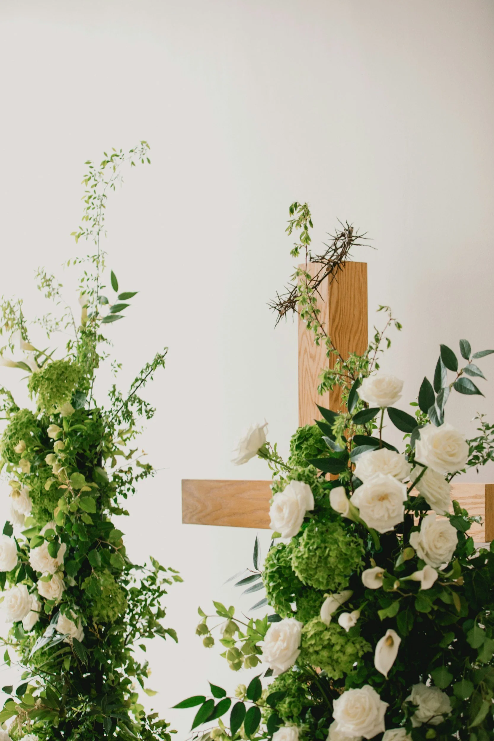 Arrangement of green and white flowers with greenery in a floral display.