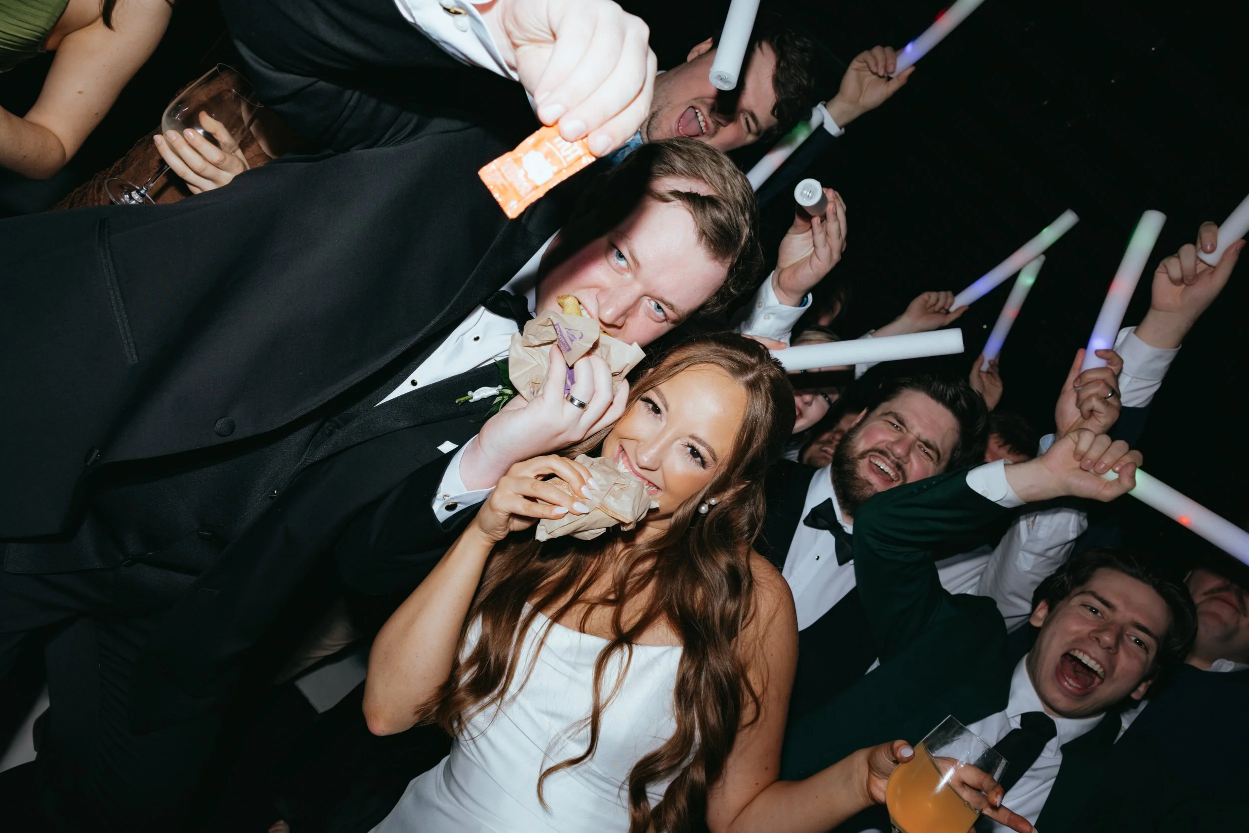 People in formal attire enjoying drinks and snacks at a celebration or party.