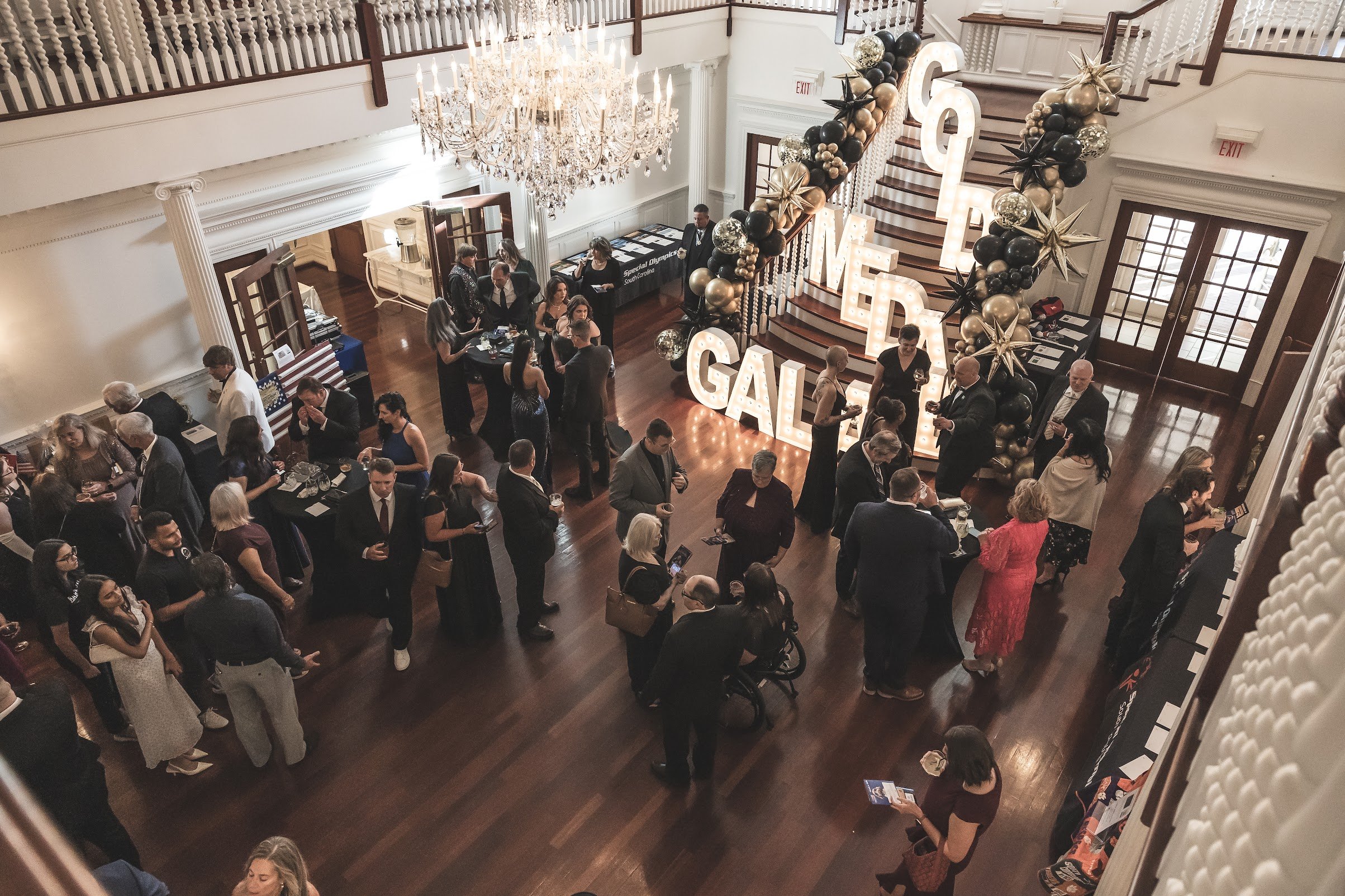 People socializing at an indoor event with a large illuminated