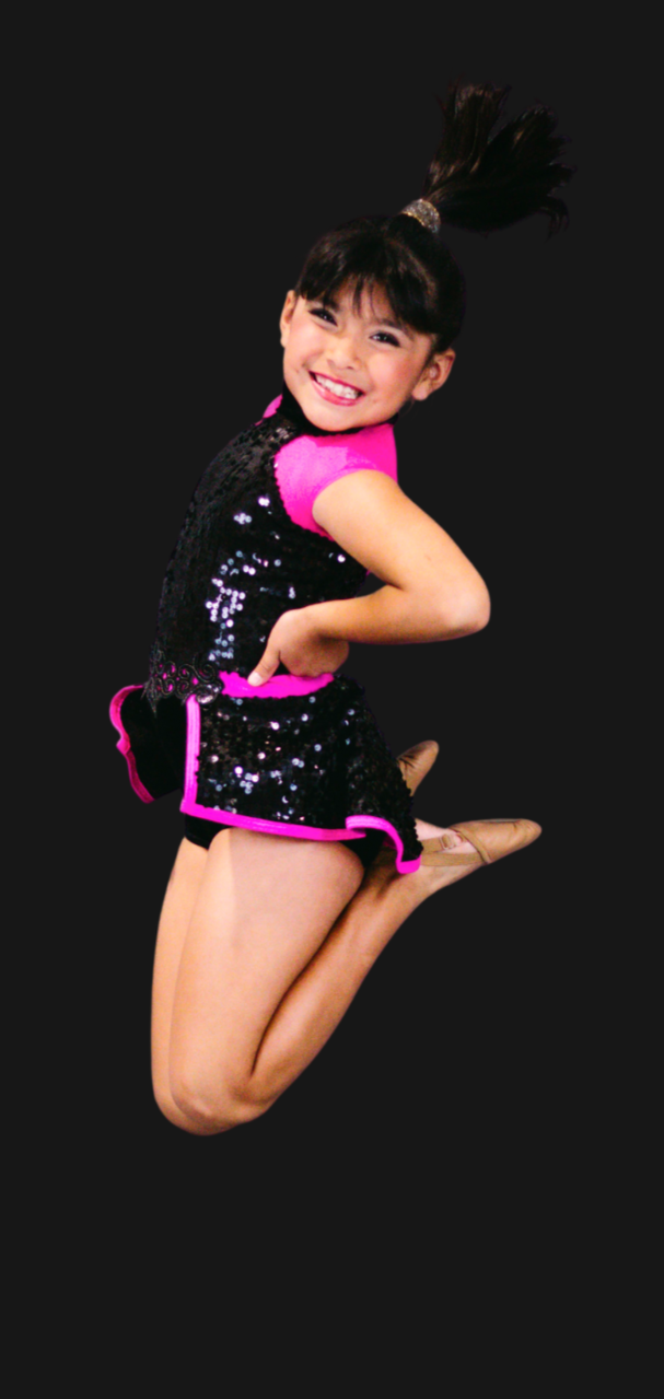 Young girl in a black and pink dance costume performing a jump against a black background.