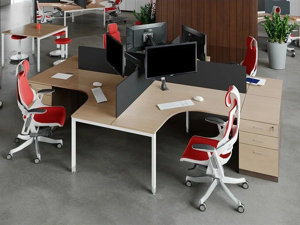 Bunbury Physio Sylex Office Furniture - Modern office workspace with four desks, each with computer monitors, keyboards, mice, and swivel chairs with red and white accents. There are potted plants and additional seating and desks in the background.