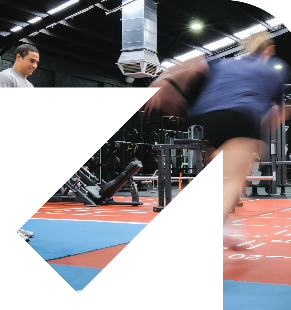 Bunbury Physio - A gym scene with a man smiling on the left and a person in blue workout attire doing a workout on the right, with gym equipment and a running track in the background.