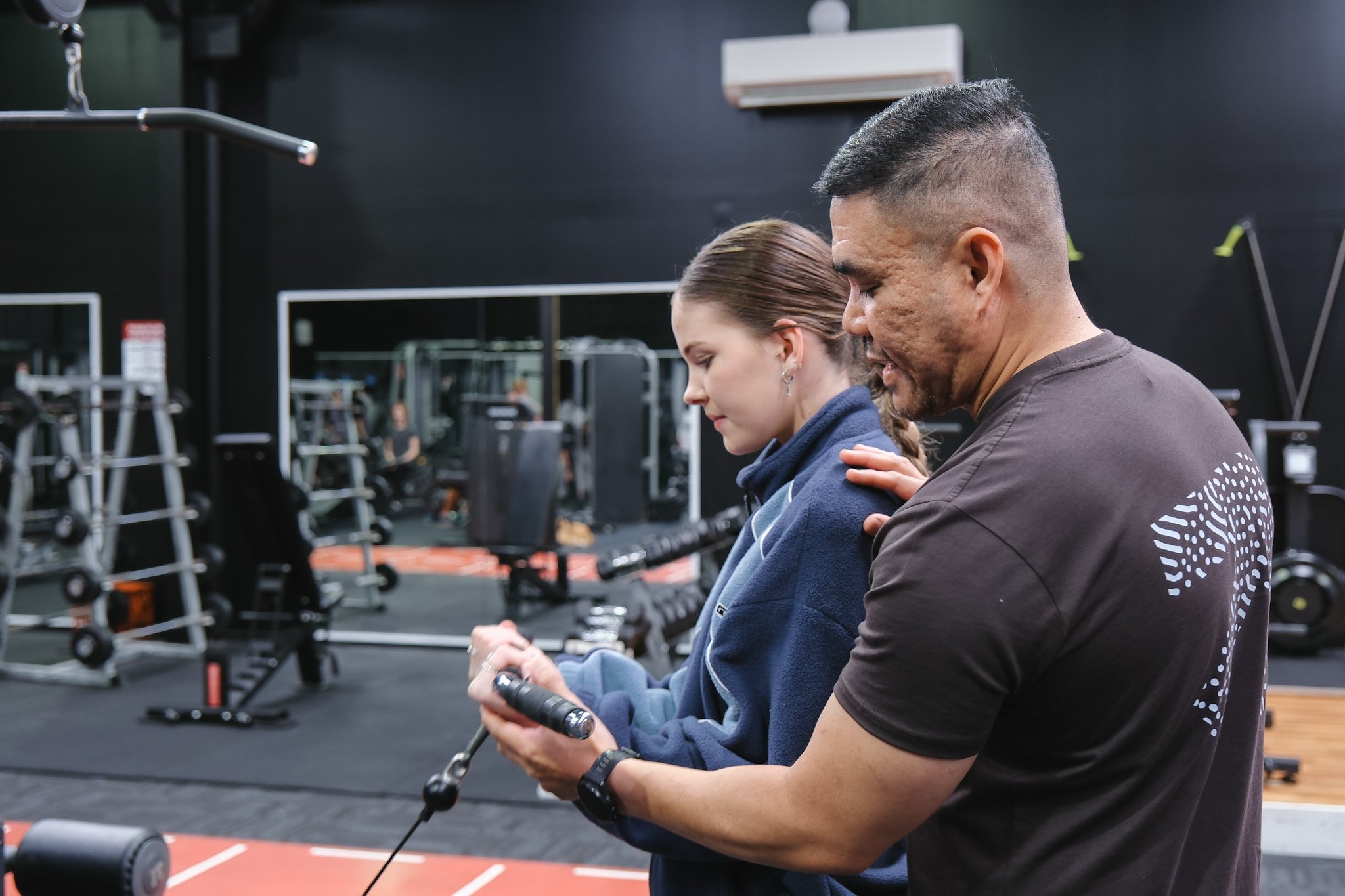 Bunbury Physio - A man and a woman standing in a gym, both holding jump ropes and preparing for exercise, with gym equipment visible in the background.