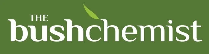 Logo with the text 'The Bushchemist' in white on a green background, featuring a small green leaf above the 'h'.