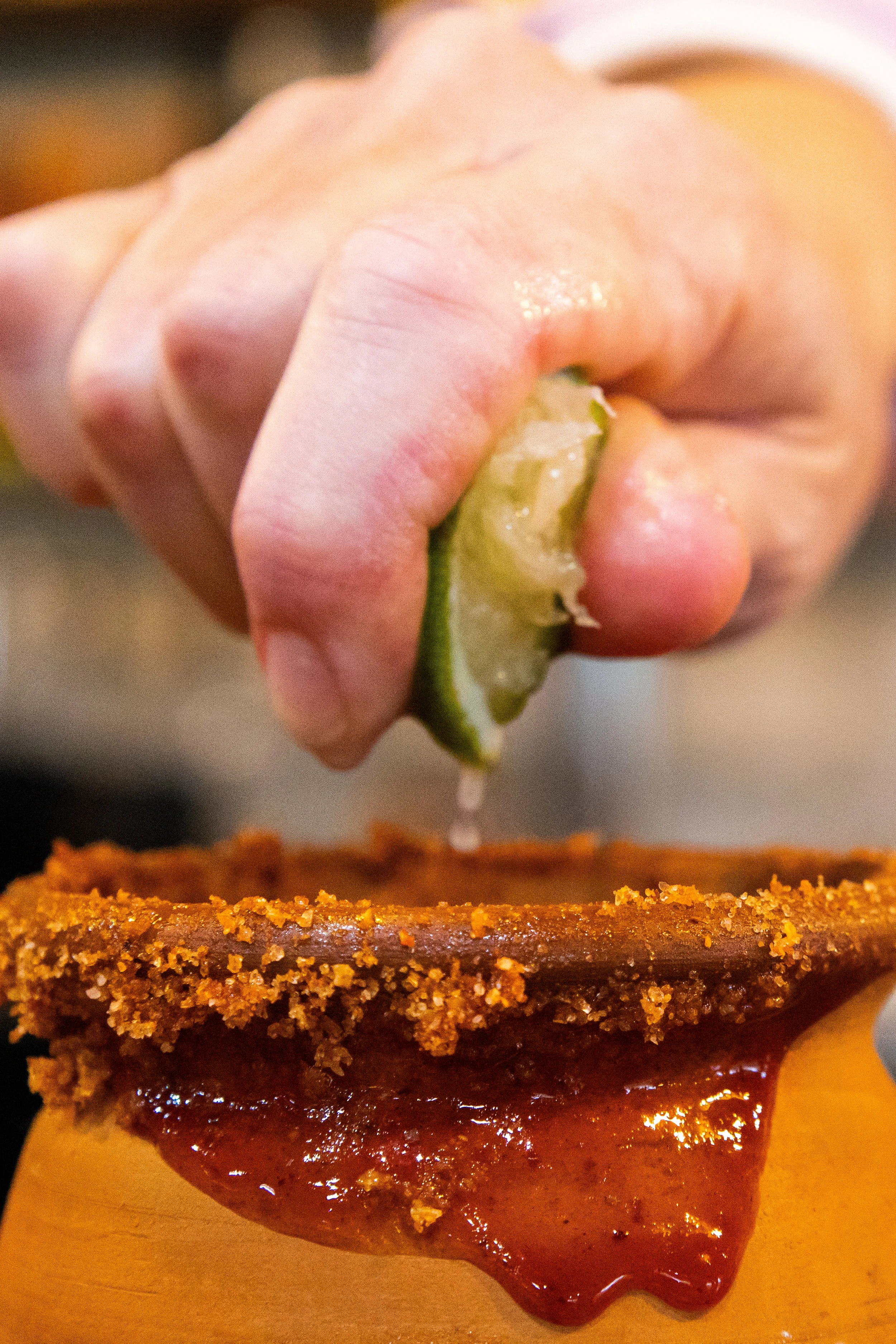lime being squeezed into a drink