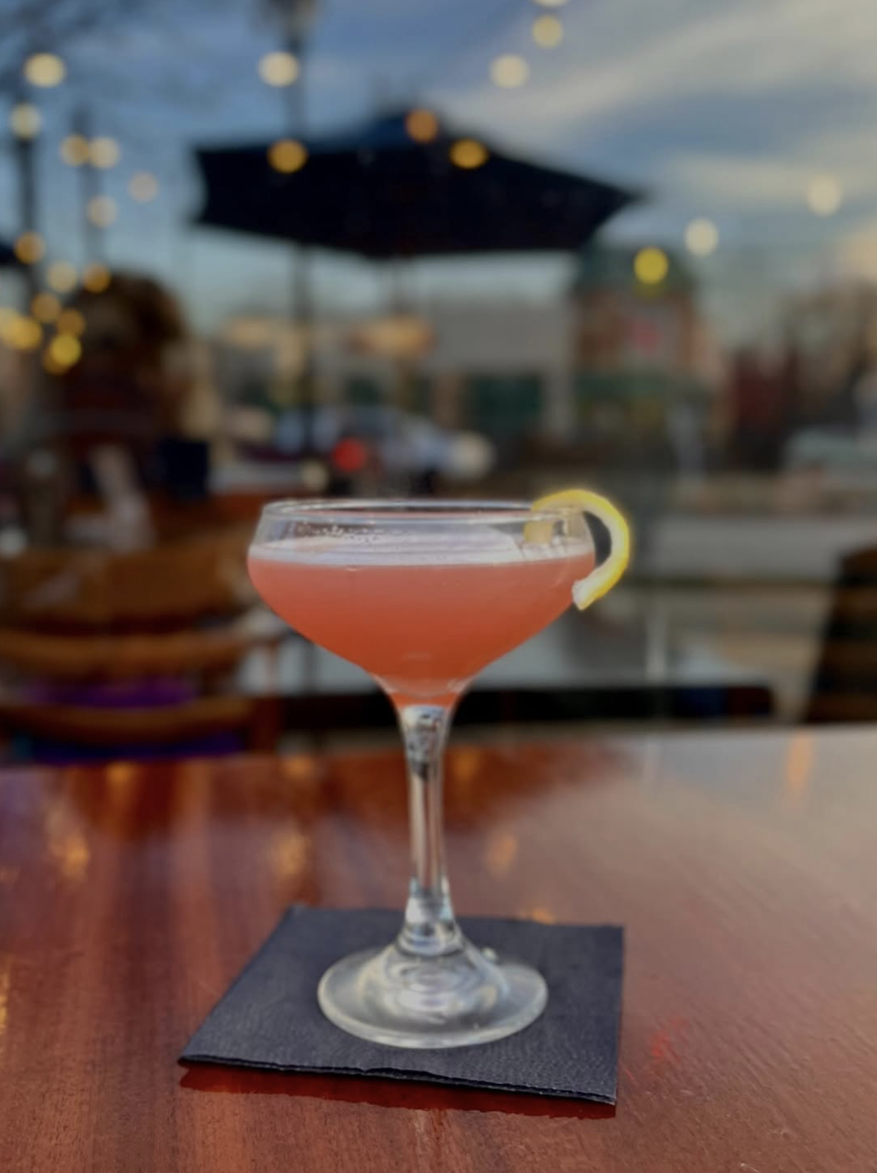 pink cocktail with lemon wedge