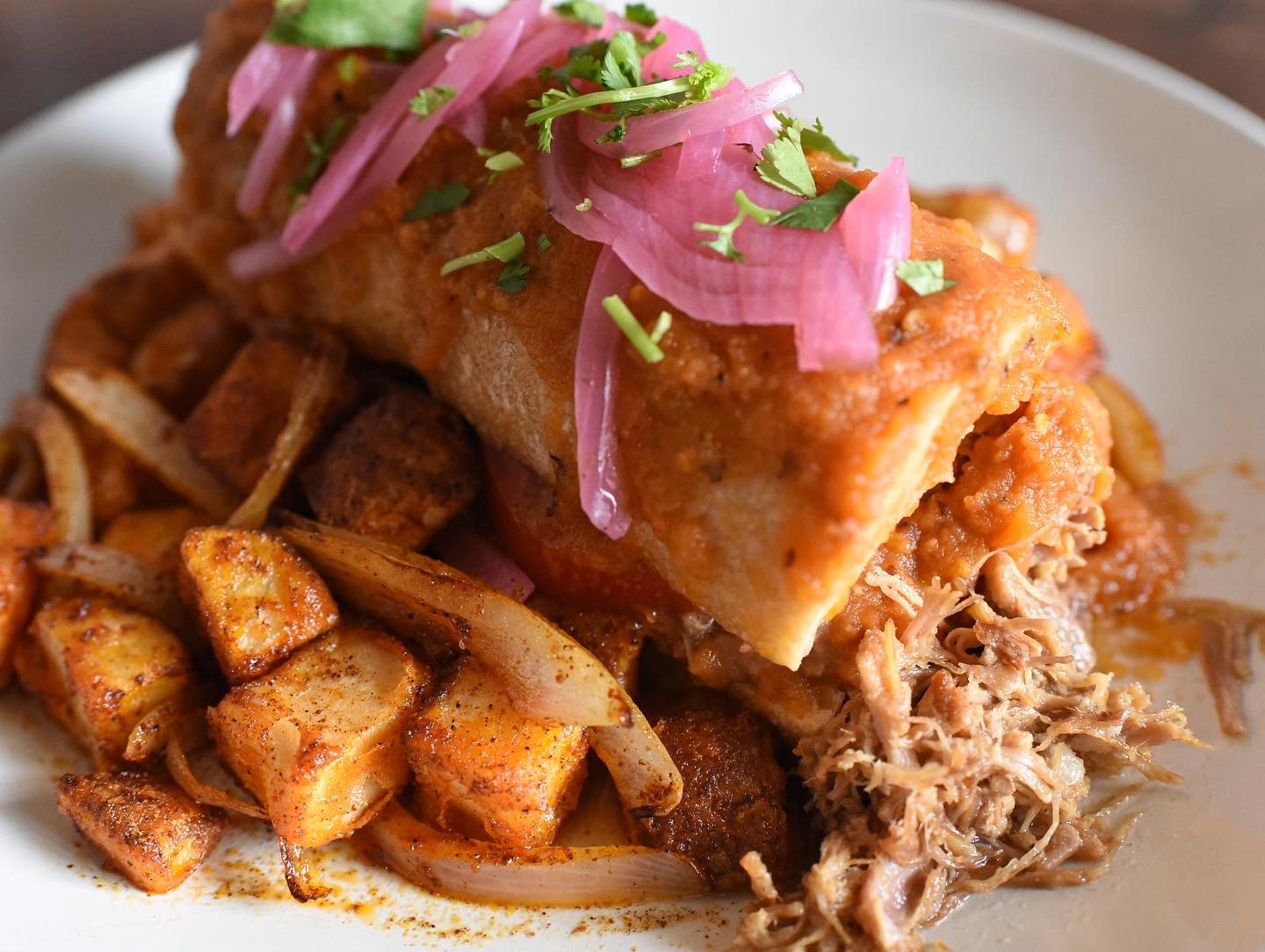 breakfast sandwich with potatoes and pickled onions on top
