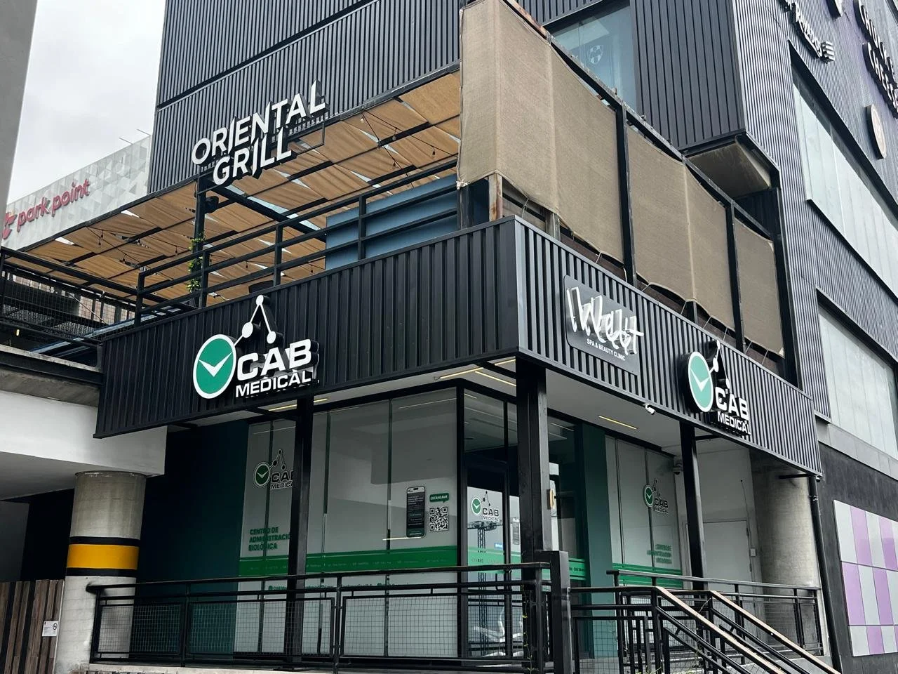 Edificio con fachadas de color negro y cartel de 'CAB Medical', y otros en el segundo piso como 'Oriental Grill' y 'Evet Spa & Beauty Clinic'.