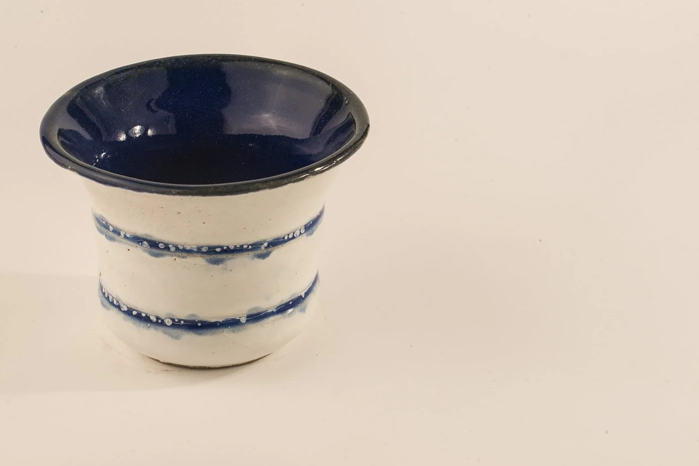 Decorative ceramic bowl with a blue and white design, positioned on a plain white surface.