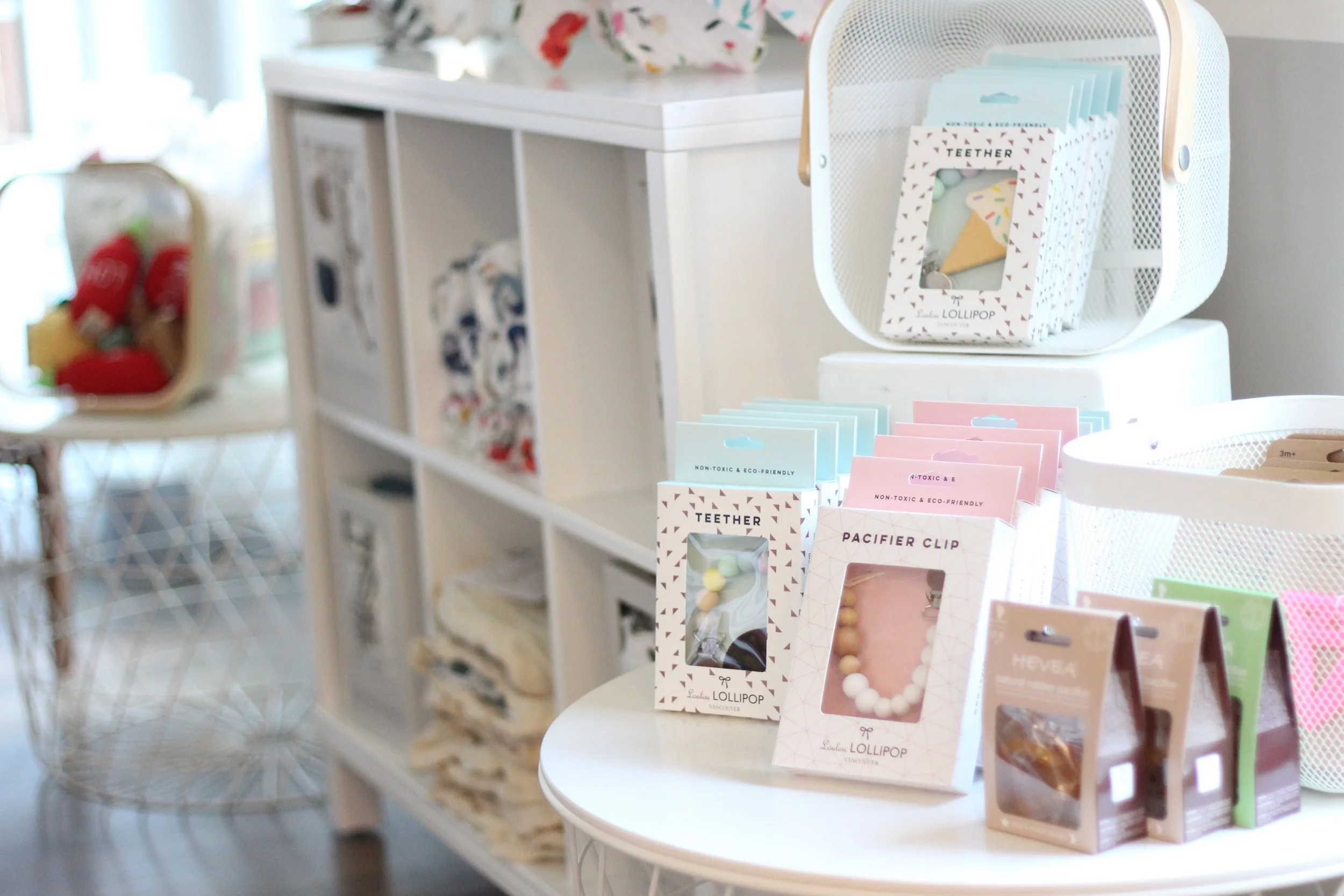 Display of colorful stationery and small gift boxes on a white table in a retail store.