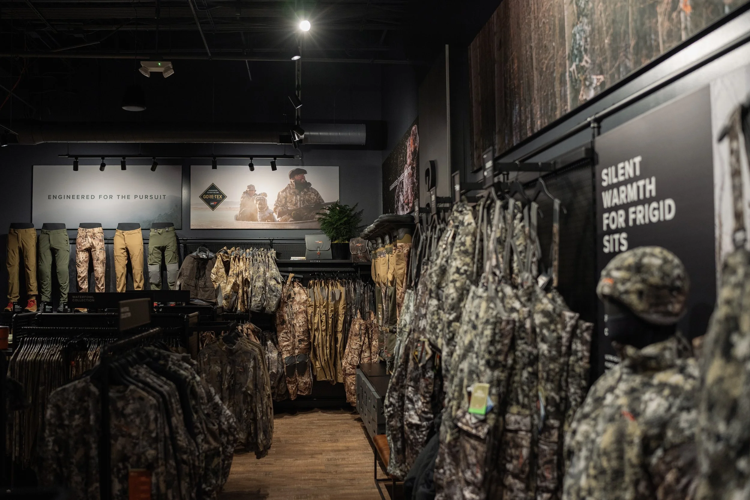 Military camouflage clothing and gear on display in a retail store.