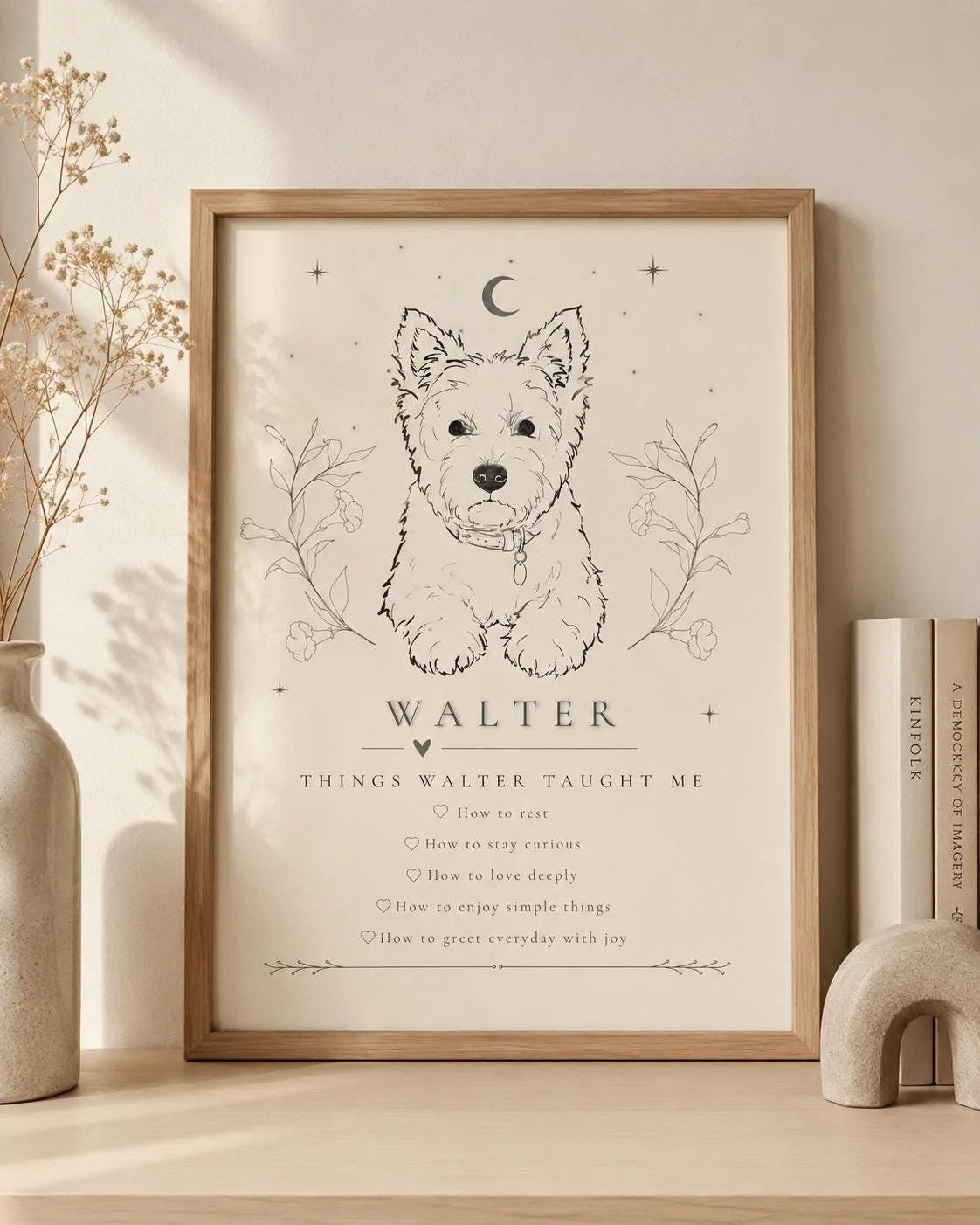 Framed art print featuring a line drawing of a dog, likely a West Highland White Terrier, with celestial symbols above and floral accents on either side. Text below the dog reads 'Walter' and lists lessons learned from Walter, including resting, curiosity, love, enjoying simple things, and greeting every day with joy.