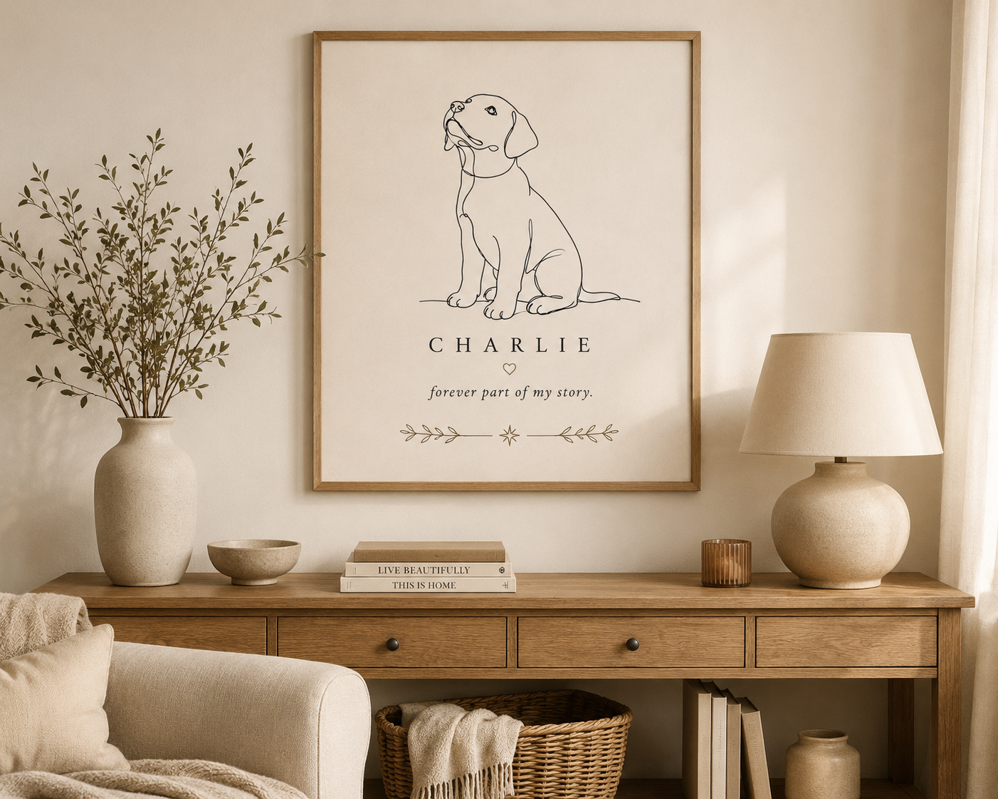 Living room with a wood console table, large framed art featuring a line drawing of a dog named Charlie and the text 'forever part of my story,' a beige lamp, a couple of books, and decorative items including a vase of greenery and a small candle.
