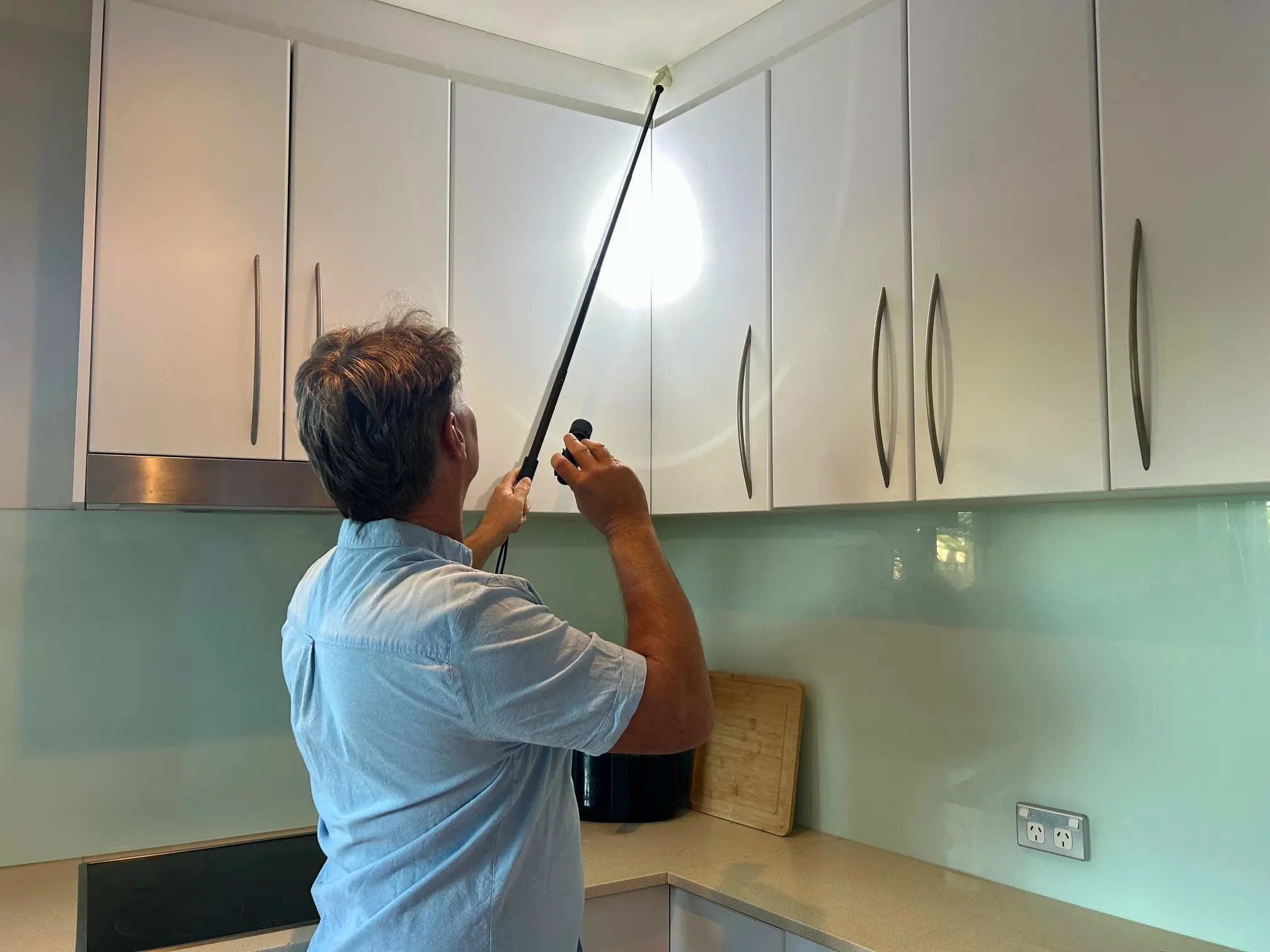 Shane Macfarlane inspecting a kitchen during a building and pest inspection.
