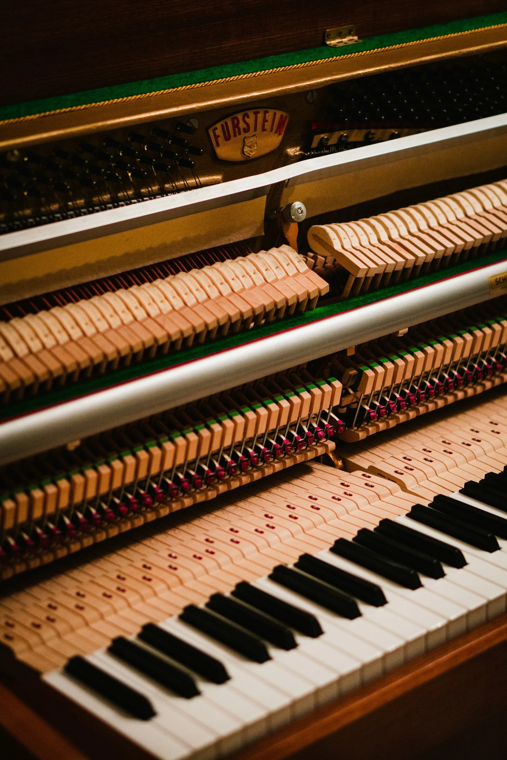 A close-up view of the inner mechanisms of a piano, promoting piano tuning, minor repair and regulation in Bakersfield, CA and Kern County.