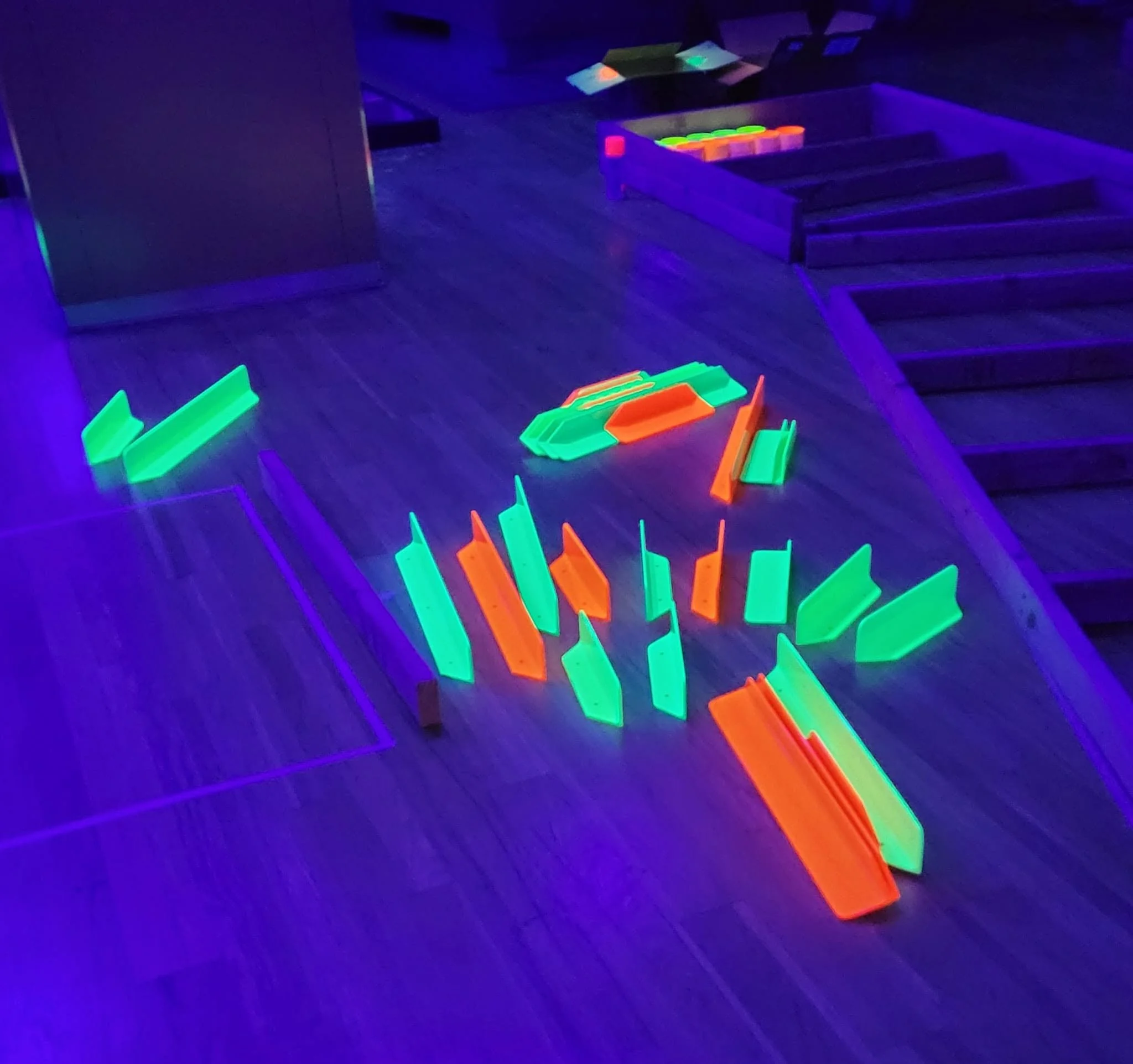 Custom-fabricated metal components coated in high-visibility fluorescent powder for industrial or safety applications.