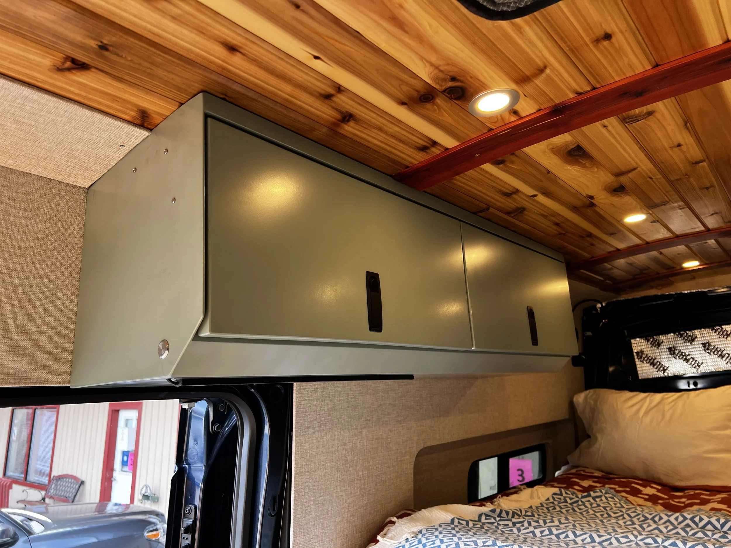 Custom metal storage cabinetry fabricated for van conversion and residential interior organization.