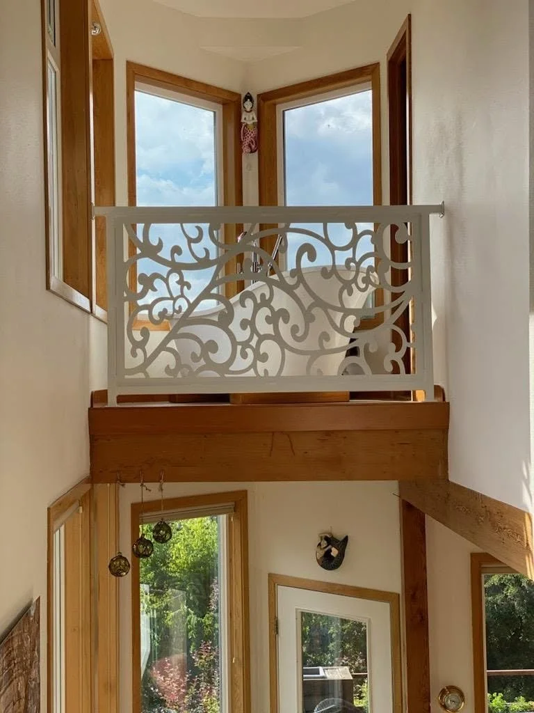 Custom CNC-cut interior metal stair railing with ornate decorative floral patterns.