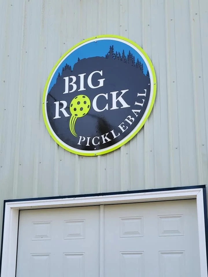 Round metal sign for Big Rock Pickleball, featuring custom-fabricated logo and branding.